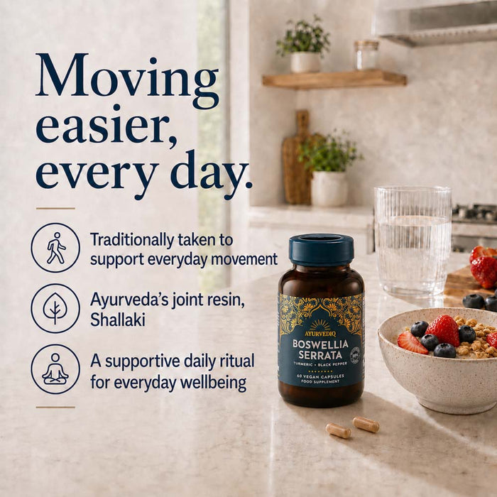 A bottle of Boswellia Serrata dietary supplement placed on a kitchen countertop beside a glass of water, with the informational text 'Moving easier, every day.'