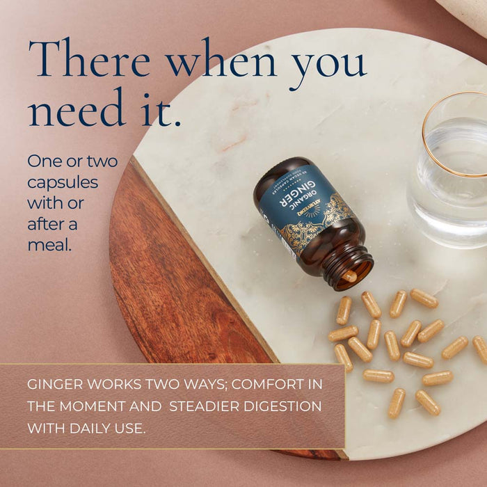A bottle of ginger capsules lies on a white marble tray with scattered tan capsules beside it, alongside a glass of water. Large text reads, 'There when you need it.