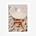 A photo wall art print featuring a woman on the beach wearing a Beach Hat in the sand