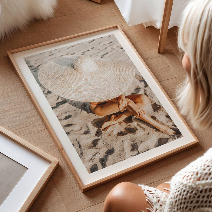 Framed photography wall art print of a person on the beach wearing a straw hat to showcase a luxury lifestyle.
