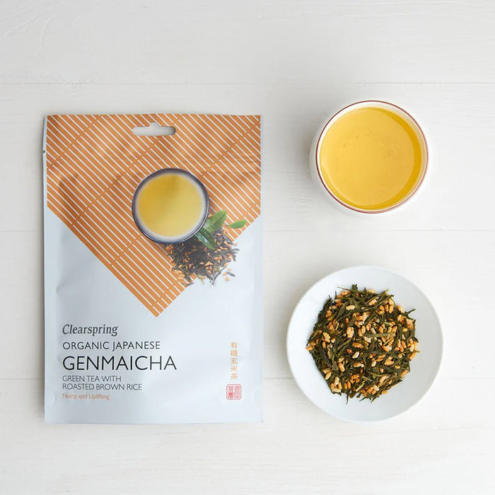 Clearspring Organic Japanese Genmaicha packaging with a cup of tea and a bowl of green tea leaves on a white background