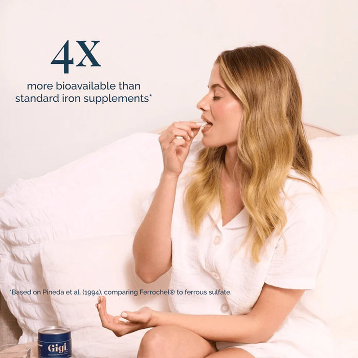 Woman taking a supplement with a container labeled '4X' on a light background
