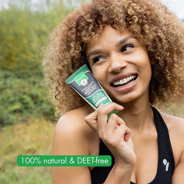 Woman holding a 100% natural and DEET-free product with a green background