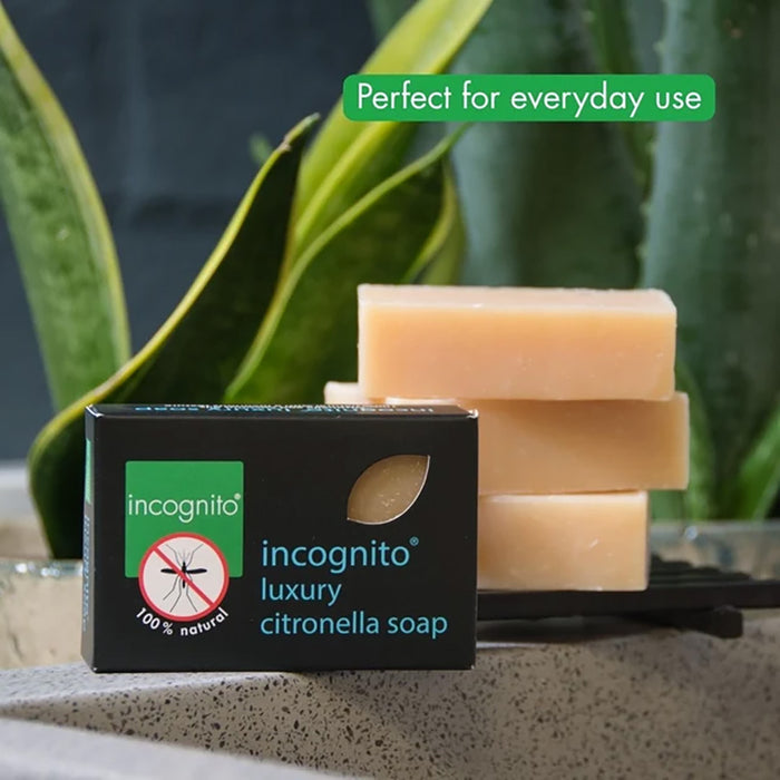 Incognito luxury citronella soap with packaging on a surface with plants in the background.