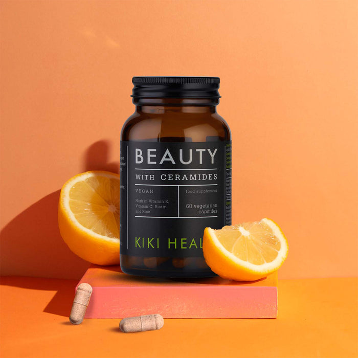 Vitamin supplement bottle labeled 'Beauty with Ceramides' on an orange background with lemons.