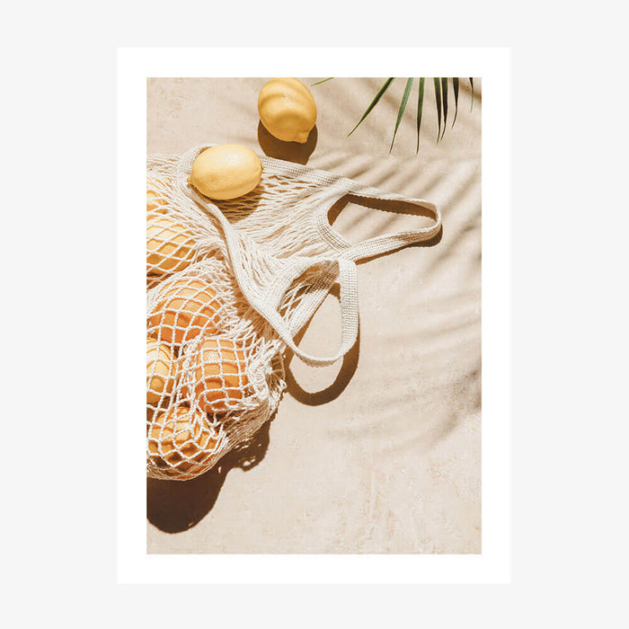 A photo wall art print featuring lemons on the beach