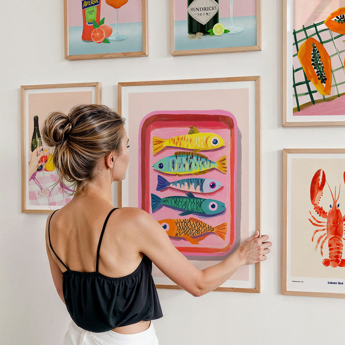 A gallery wall of framed artwork print on a wall featuring food, drinks and kitchen items.