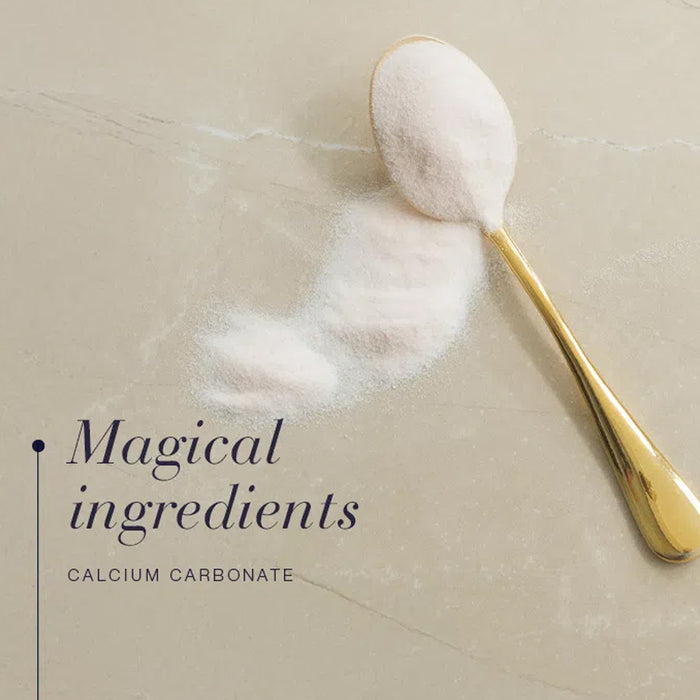 Gold spoon with calcium carbonate powder on a beige surface, text 'Magical ingredients Calcium Carbonate' below.