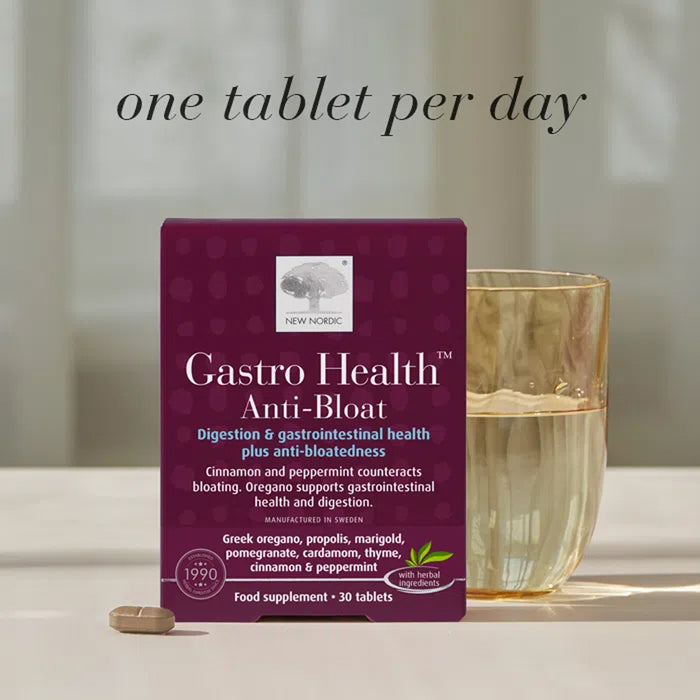 Gastro Health Anti-Bloat supplement packaging with a glass of water on a neutral background