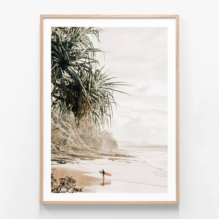 A framed wall art print featuring a surfer on the beach in Noosa