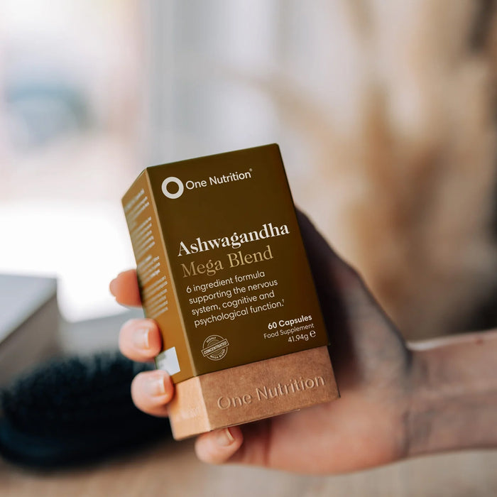 One Nutrition Ashwagandha Mega Blend packaging held by a person with a blurred background