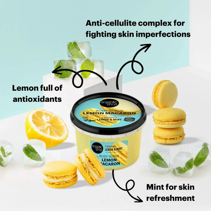 Organic Shop Lemon Macaron Firming Body Scrub, surrounded by lemons, macarons, and mint leaves on a light blue background.