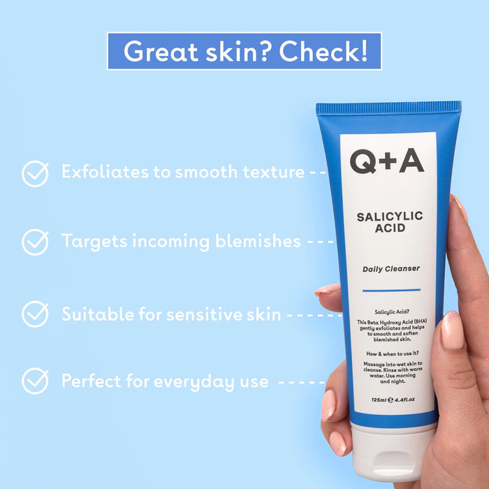 Q+A Salicylic Acid Daily Cleanser tube held by a hand with text on a blue background