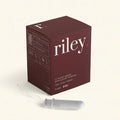 Maroon box of 'riley' tampons with a tampon attached on a light beige background