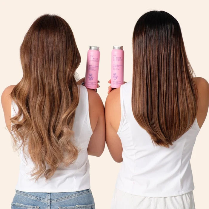 Two women with long, wavy hair holding pink bottles against a beige background