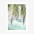 A framed photo wall art print featuring turquoise ocean waters with a palm tree along a tropical coastline