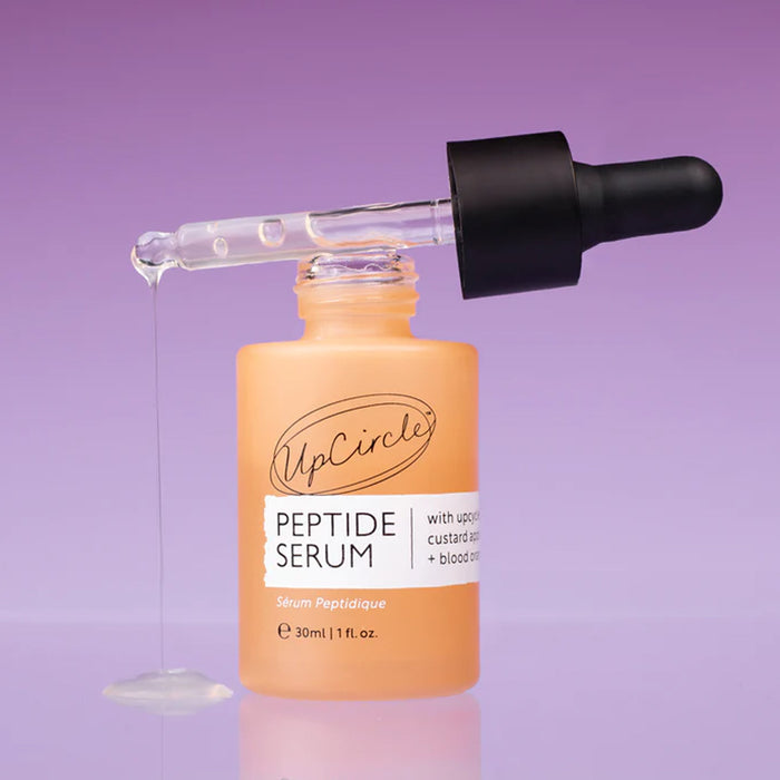 UpCircle Peptide Serum bottle with dropper on a purple background