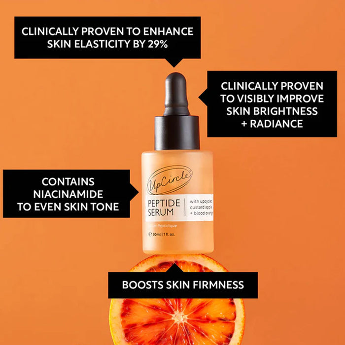 UpCircle peptide serum bottle with orange slices on an orange background