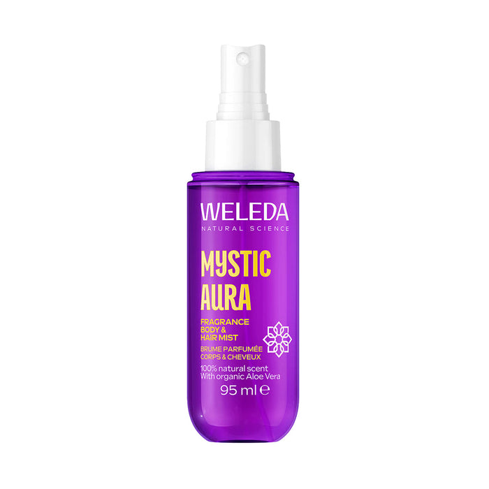 A spray bottle of Weleda Mystic Aura body and hair mist, featuring a vibrant purple bottle with a white spray top, set against a plain white background.