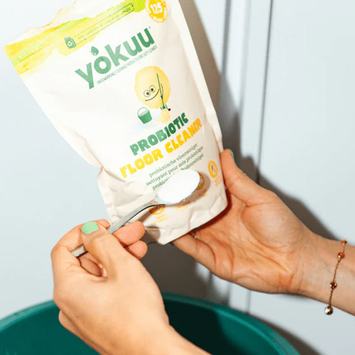 Person scooping yokuu probiotic flour from a package with a spoon.