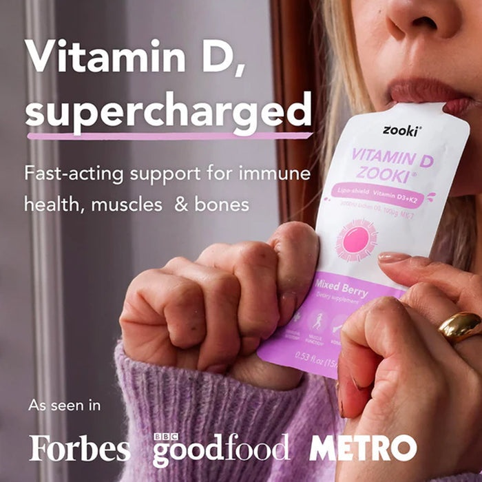 Person holding a Zooki Vitamin D supplement with branding and product details.
